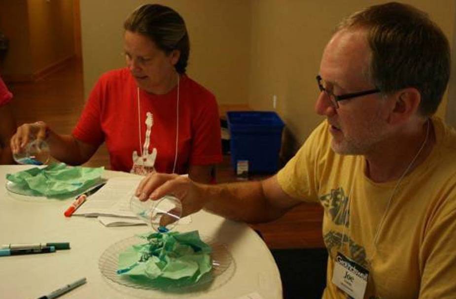 Teachers pouring water on watershed models